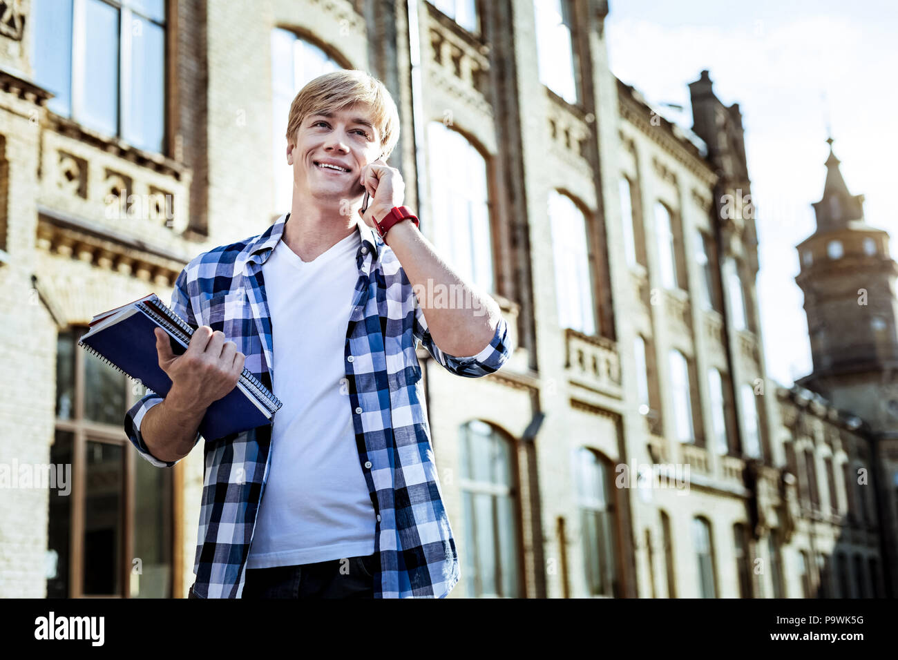 Express positività. Felice l'uomo mantenendo il sorriso sul suo volto e si inchinano testa avendo al contempo piacevole parlare Foto Stock