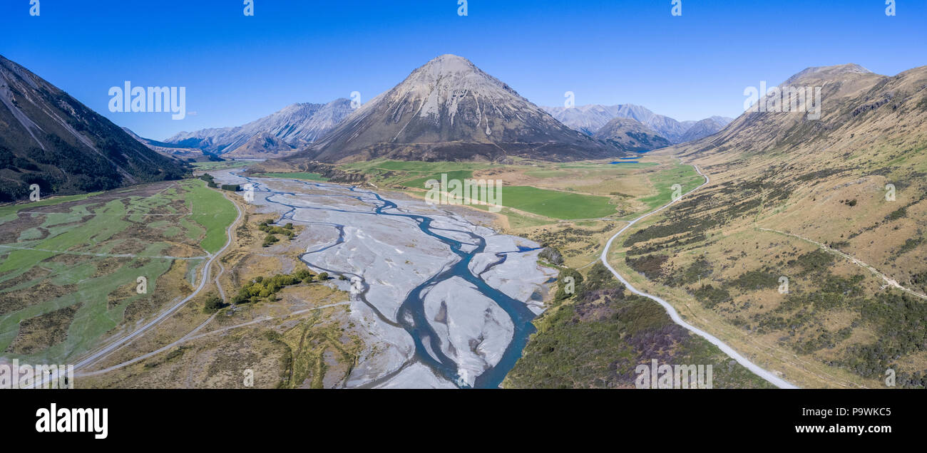 Drone shot, serpeggiante fiume in alveo di spazzamento con montagne, Harper River, Monte Ida, regione di Canterbury, Isola del Sud Foto Stock