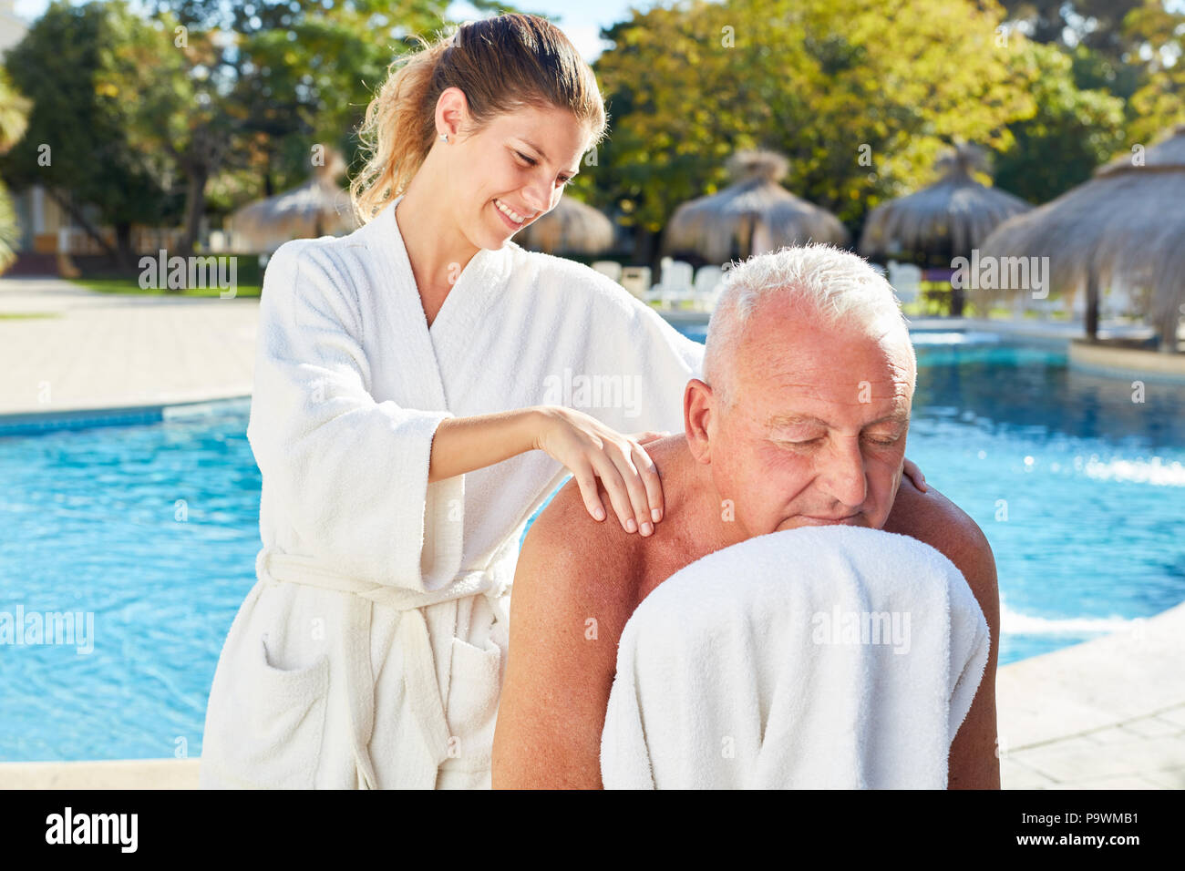 Il vecchio uomo dalla piscina diventa un sano massaggio alla schiena da pool dalla spa Foto Stock