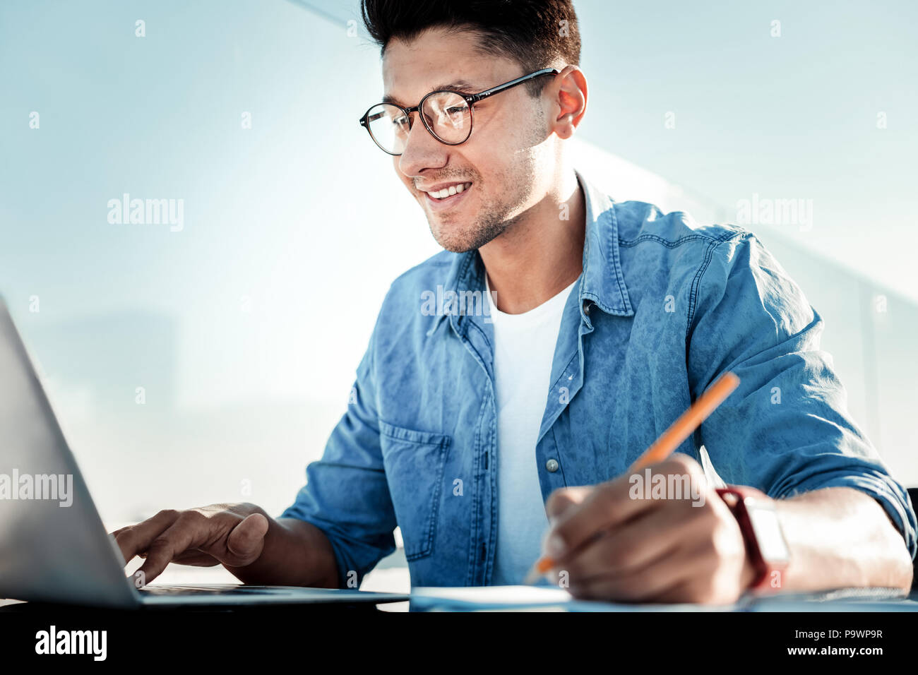 Attraente brunette uomo mentre si lavora al progetto Foto Stock