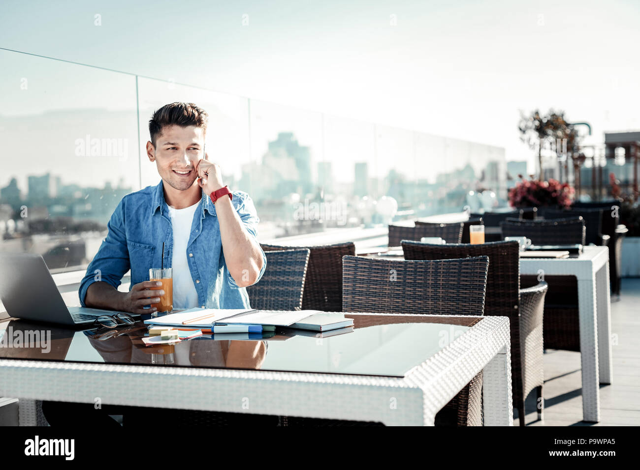 Positivo lieto uomo seduto sulla terrazza Foto Stock