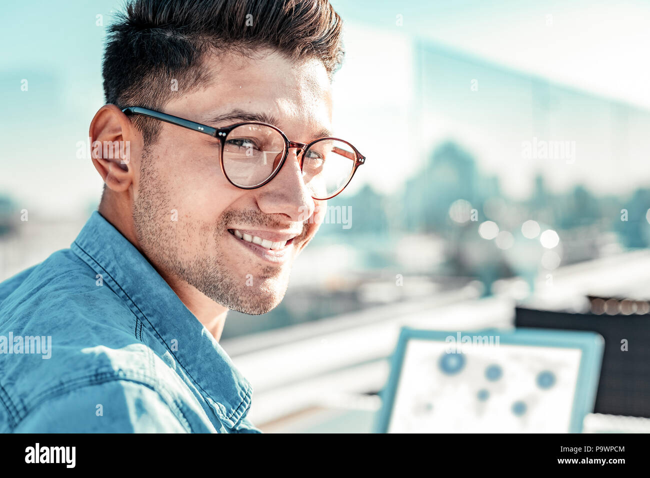 Ritratto di felice la persona di sesso maschile che posa su telecamera Foto Stock