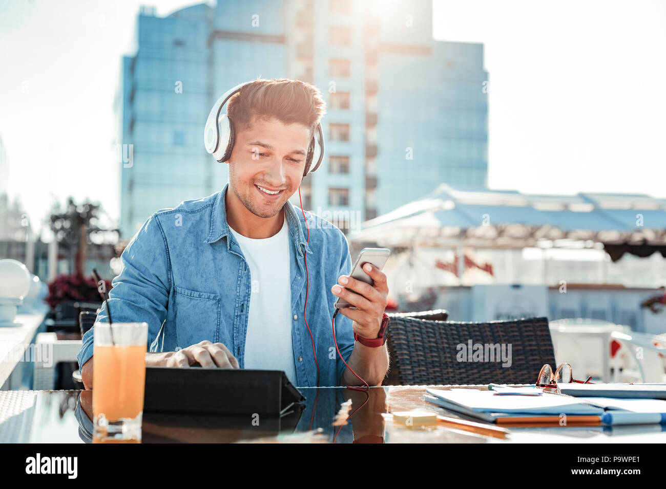 Uomo gioioso a giocare con i suoi gadget Foto Stock