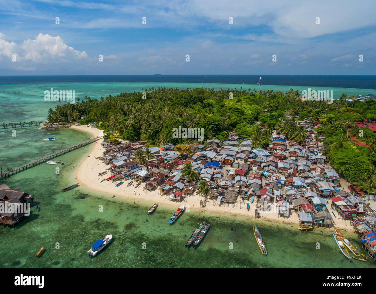 Drone foto di un pessimo Bajau zingari del mare village a Mabul Island, Sabah, Malesia, Borneo), con il mare tropicale, cielo blu e nuvole in background. Foto Stock