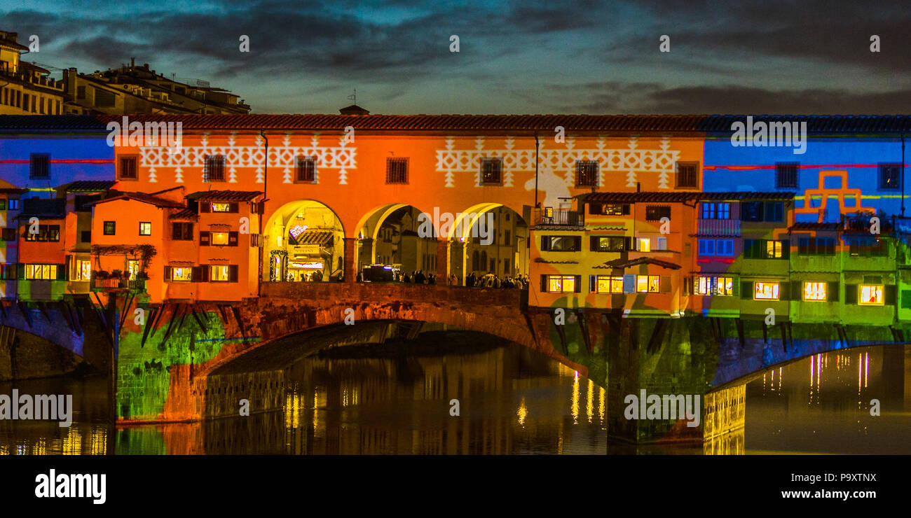 Il Ponte Vecchio è una pietra medievali chiuso-spandrel arco ponte sopra il fiume Arno a Firenze, nota per aventi ancora negozi costruiti lungo di esso, come era una volta comune. Macellerie inizialmente occupata dai negozi la presente gli inquilini sono i gioiellieri, i commercianti di opere d'arte e venditori di souvenir. Foto Stock