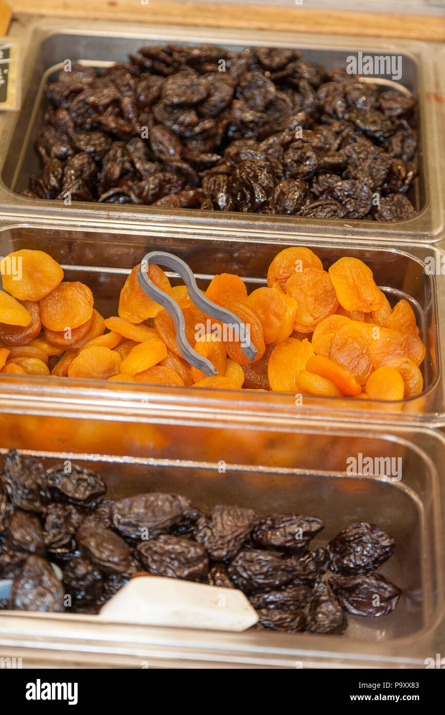 Asciugare le susine e albicocche a secco in un contenitore di plastica sul display . Immagine di stock. Foto Stock