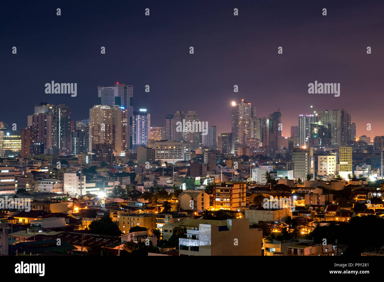 Manila skyline notturno con edifici alti e ordinaria edilizia residenziale Foto Stock