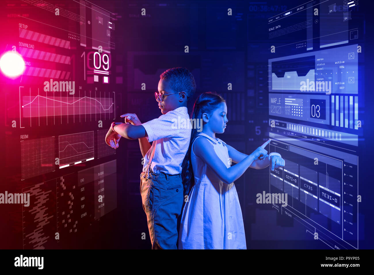 Due bambini in piedi di schiena e toccando i loro orologi smart Foto Stock