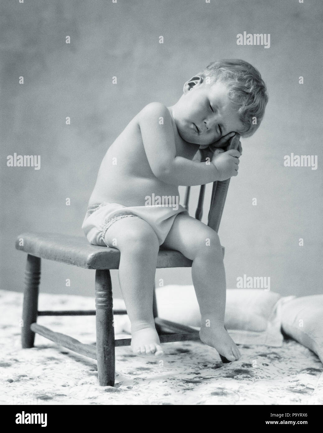 1920s 1930 Stanco BABY TODDLER indossando un panno in cotone pannolino addormentato seduto in poltrona - b10392 HAR001 HARS CADUTI NAPPING IN QUARANTA WINKS BABY BOY 40 WINKS NOVELLAME NAP il rilassamento in bianco e nero di etnia caucasica HAR001 in vecchio stile Foto Stock