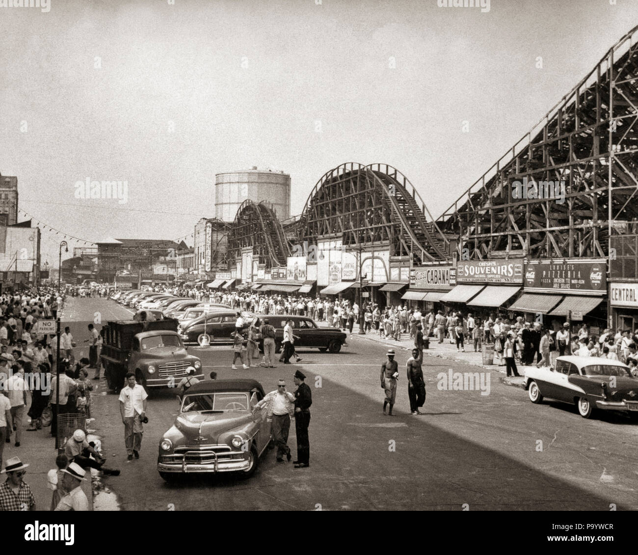 Anni Cinquanta roller coaster strade affollate di macchine parcheggiate Coney Island BROOKLYN NEW YORK STATI UNITI D'AMERICA - Q55469 CPC001 HARS AUTOMOBILE MASCHI PEDONI ENTERTAINMENT TRASPORTO B&W la libertà di successo fuori tempo ampio angolo di felicità avventura LEISURE AUTOS GETAWAY emozione ricreazione opportunità vacanze automobili ESCAPE VEICOLI ADOLESCENTE AMUSEMENTS novellame vacanze relax in bianco e nero in vecchio stile Foto Stock