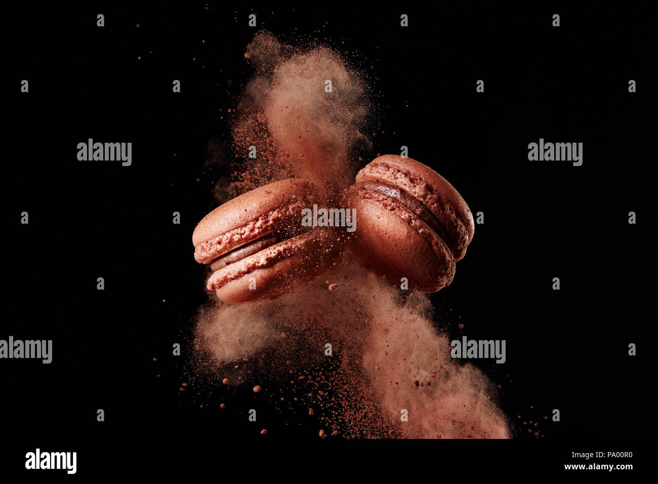 Cioccolato francese macaron con polvere di cacao su sfondo nero Foto Stock