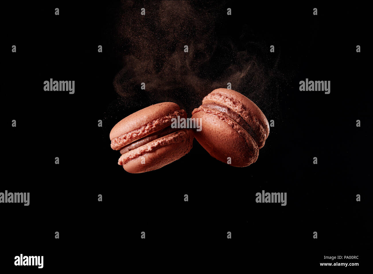 Cioccolato francese macaron con polvere di cacao su sfondo nero Foto Stock