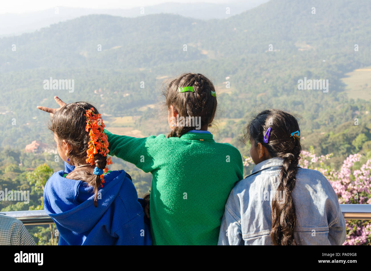 Vista dal retro di tre studentesse, godendo della vista da Raja sede del punto di vista nella Madikeri del distretto di Coorg, Karnataka, India. Foto Stock