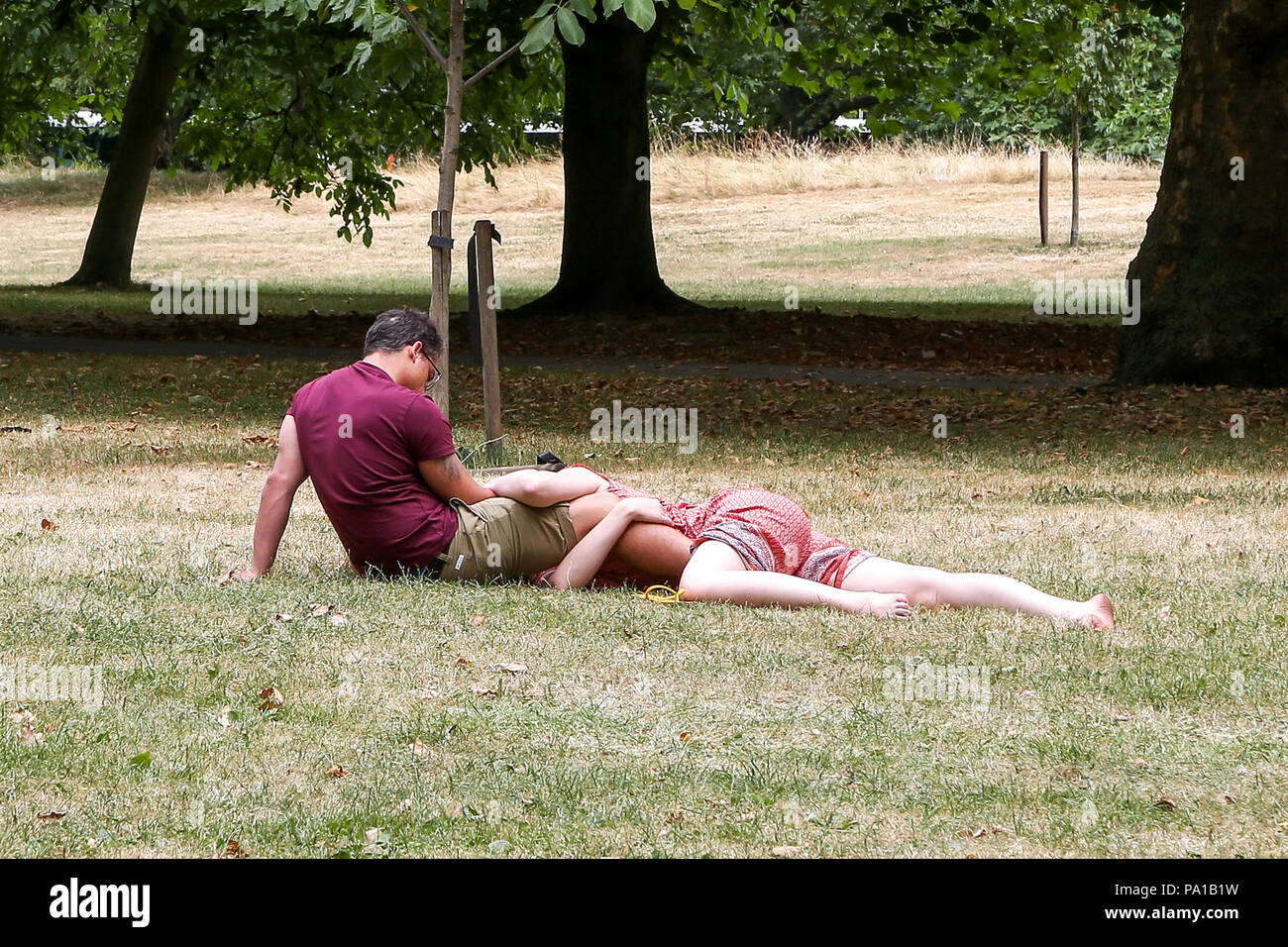 Hyde Park. Londra. Regno Unito 20 luglio 2018 - Le persone a rilassarsi sul prato arido in Hyde Park in un giorno nuvoloso nella capitale. Met Office meteo pioggia più tardi nella giornata nella capitale. Credito: Dinendra Haria/Alamy Live News Foto Stock