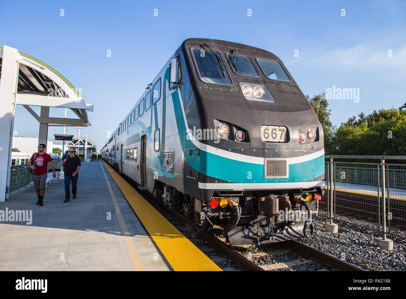 La mattina presto in direzione Sud American Metrolink treni passeggeri in partenza Tustin stazione in Orange County in California USA Foto Stock
