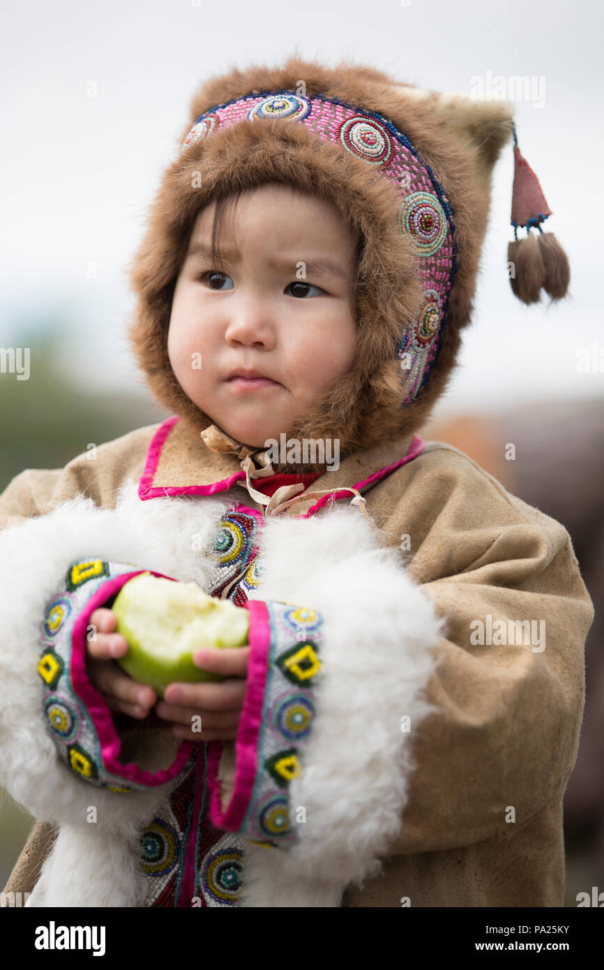 Un giovane bambino mangiare un Apple in Okhotsk Foto Stock