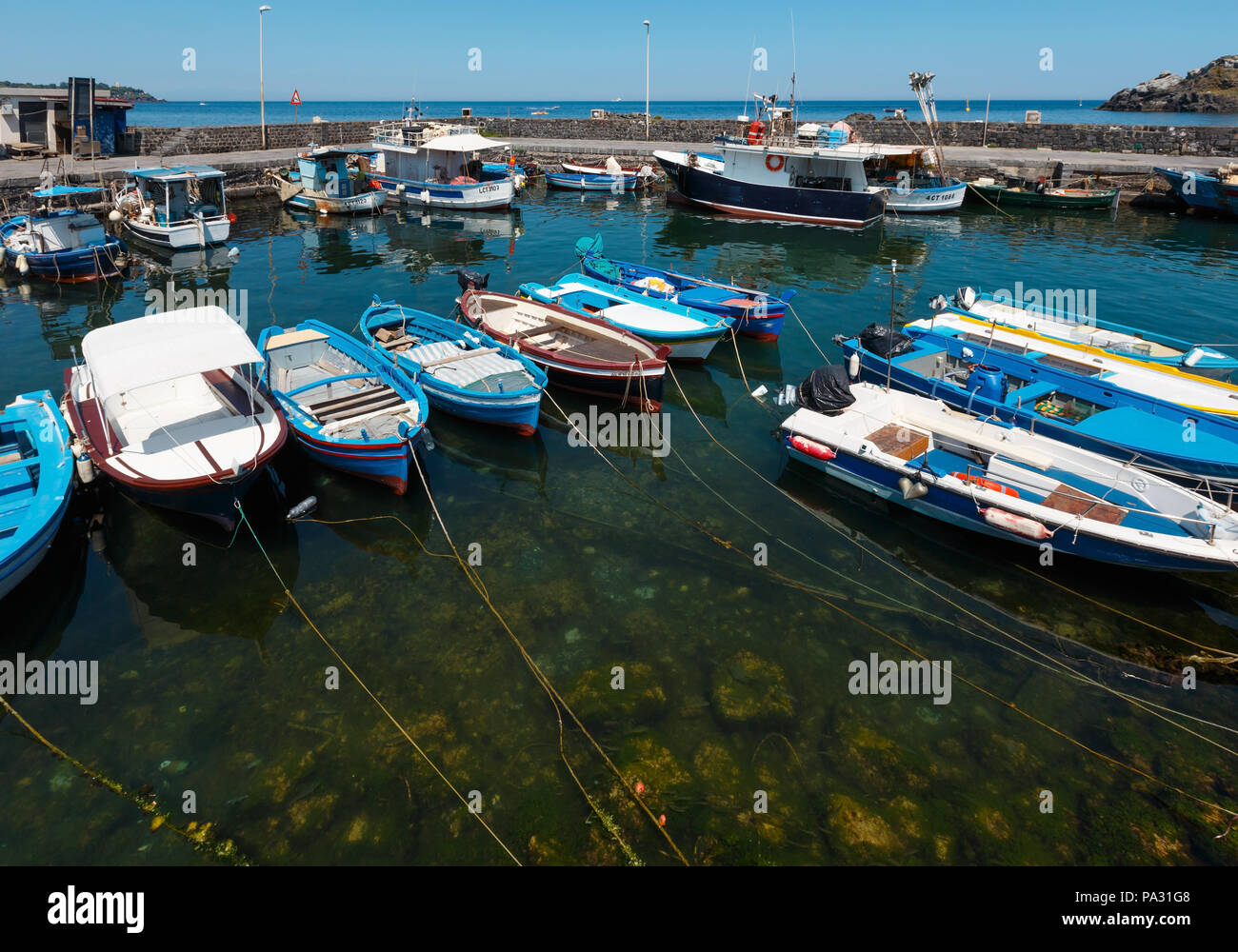 ACI TREZZA, Italia - 13 giugno 2017: Marina dei Ciclopi imbarcazioni del porto. Lachea e le isole dei ciclopi dietro (Italia, sicilia,10 km a nord di Catania Foto Stock