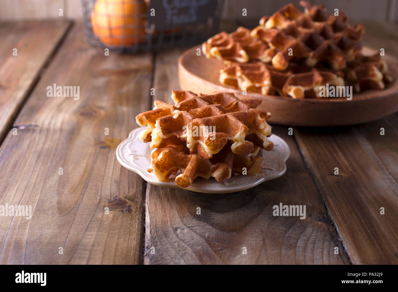 Dolce cialde belghe per la prima colazione, su una lastra di legno. Su un marrone di sfondo di legno Foto Stock