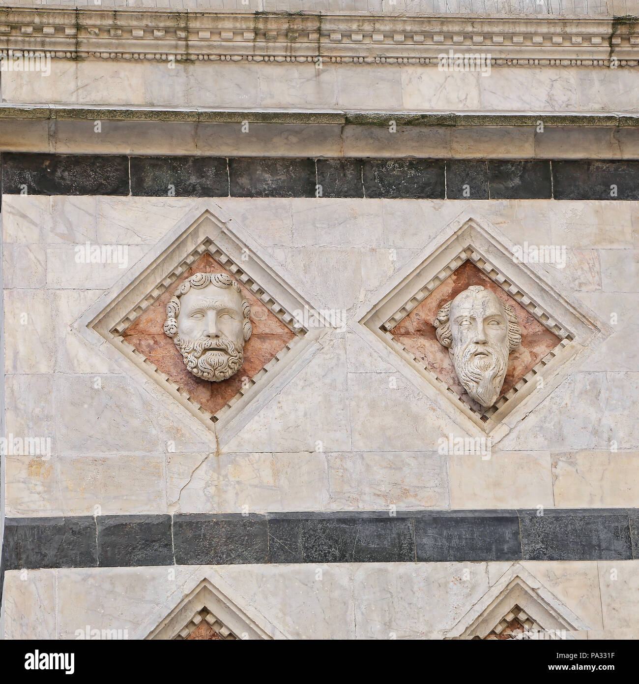 Siena - testa scolpita in marmo sulla facciata del Battistero Foto Stock