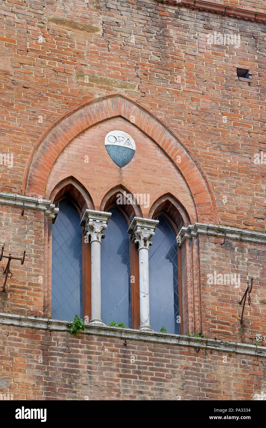 Il tipico tre-Parte gotico senese windows di Piazza San Giovanni Foto Stock