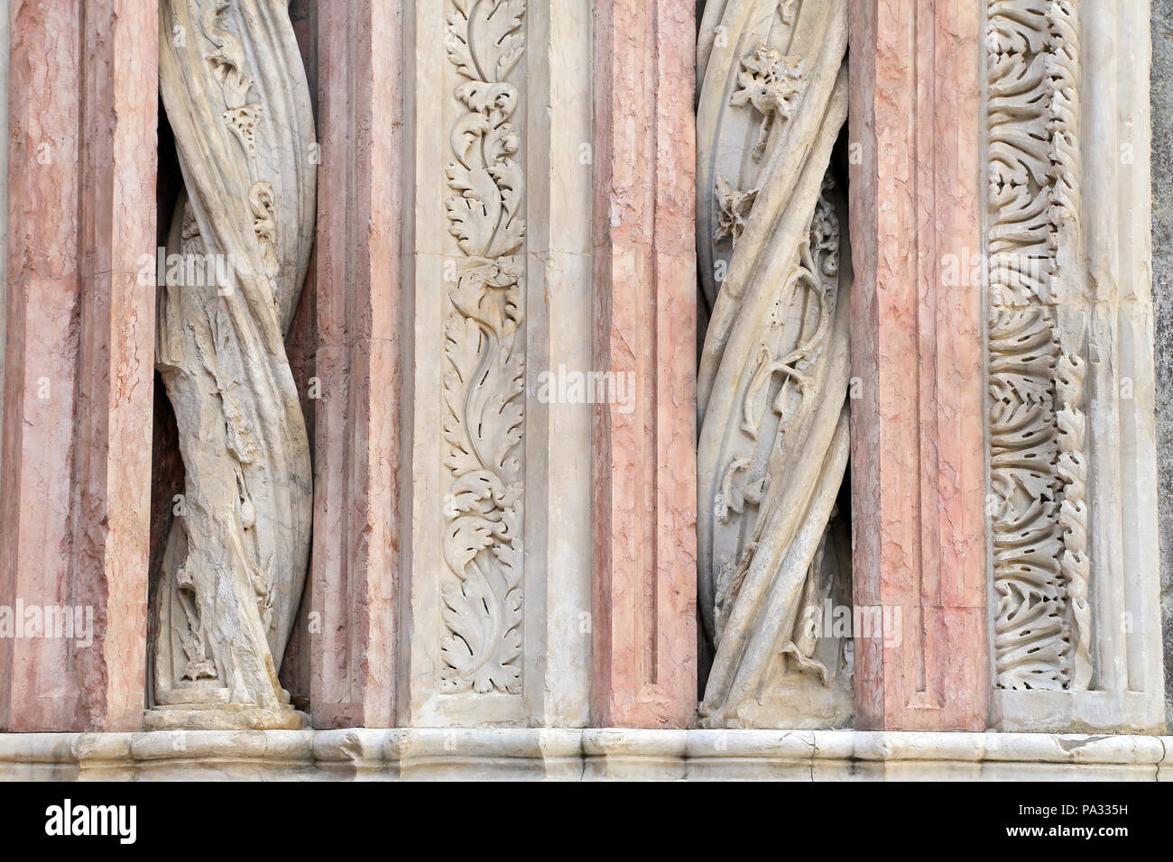 Siena - Dettagli delle colonne in marmo sulla facciata del Battistero Foto Stock