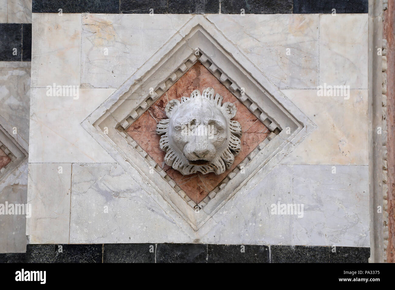 Siena - testa scolpita in marmo sulla facciata del Battistero Foto Stock