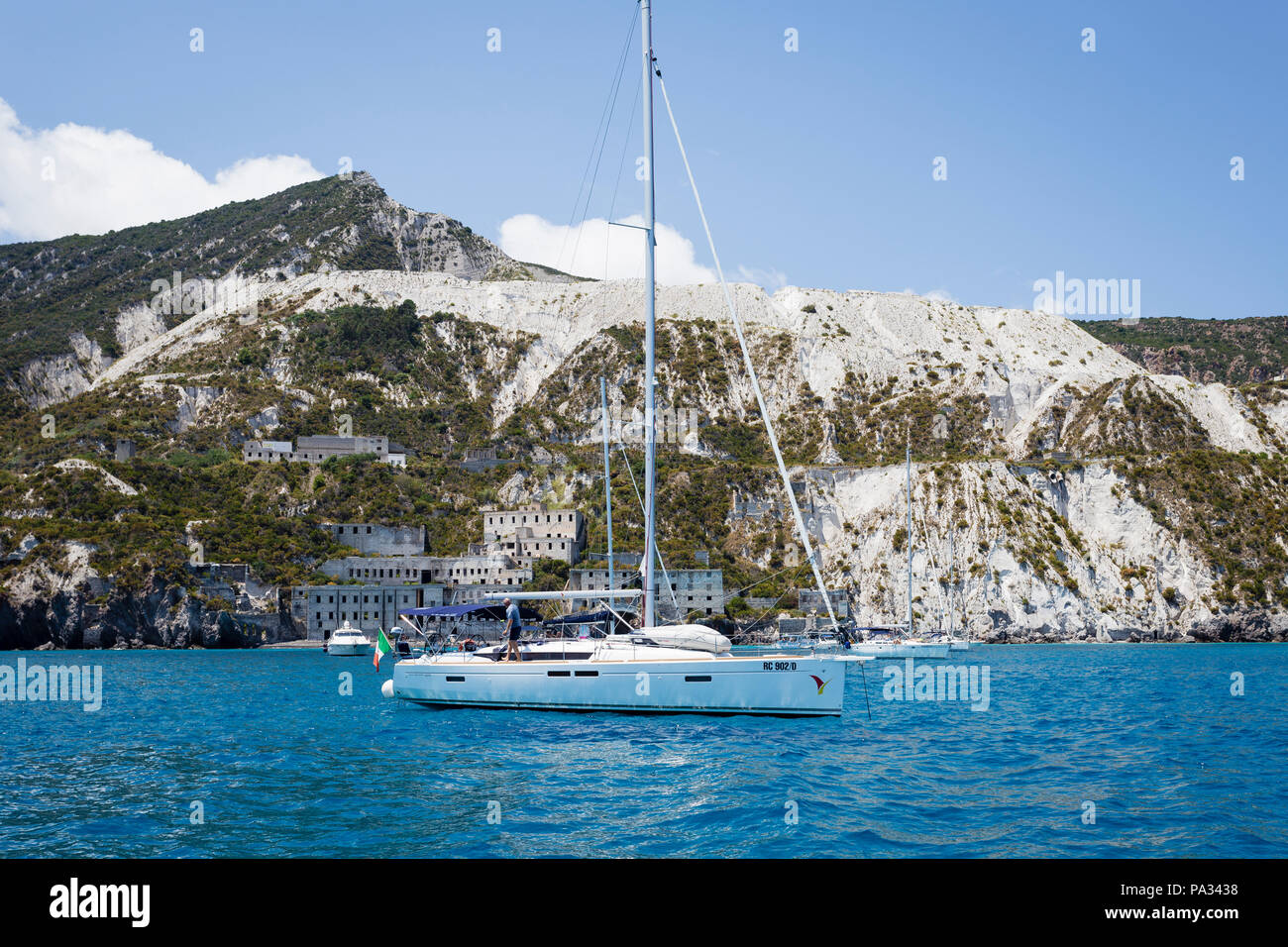 Barche ancorate nella parte anteriore delle cave di pomice (cave di pomice) sull'isola di Lipari, Isole Eolie, in Sicilia. Foto Stock