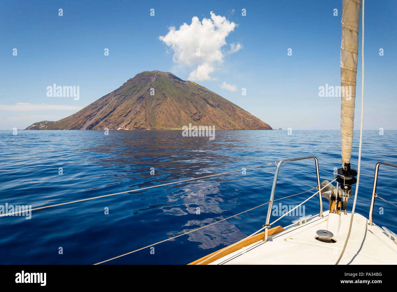 Barca a vela si avvicina l'isola vulcanica di Stromboli e le isole Eolie, in Sicilia. Foto Stock
