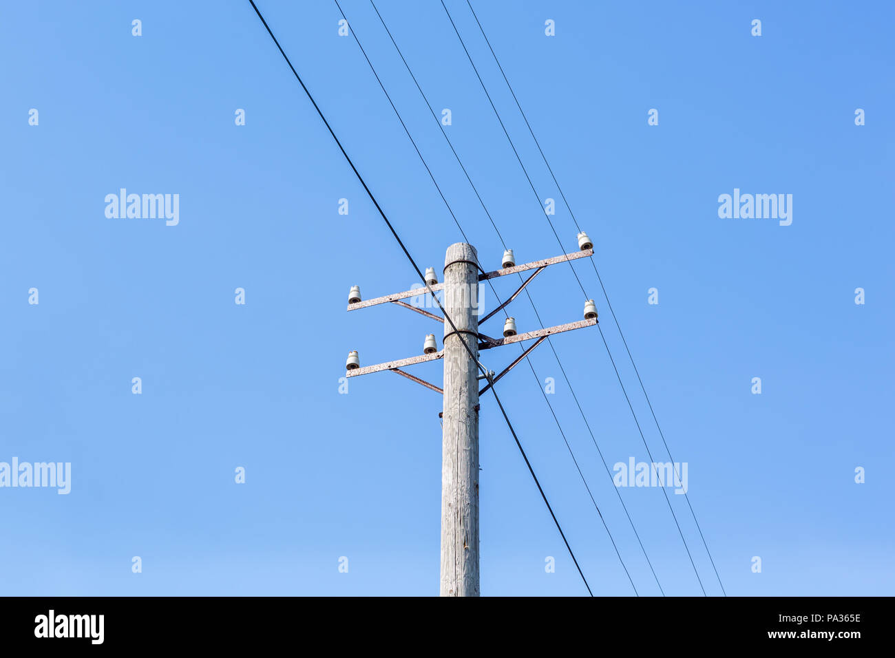 Vecchia linea telefonica contro un cielo blu chiaro Foto Stock