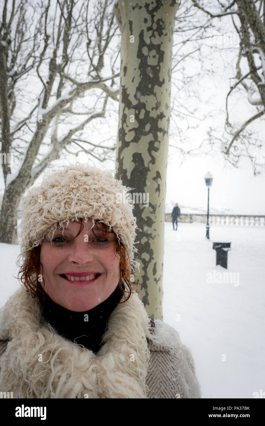 Bella donna di mezza età in uno scialle nazionale russo e pelliccia  cappotto sulla strada in inverno. La bellezza russa sorride e guarda la  fotocamera Foto stock - Alamy