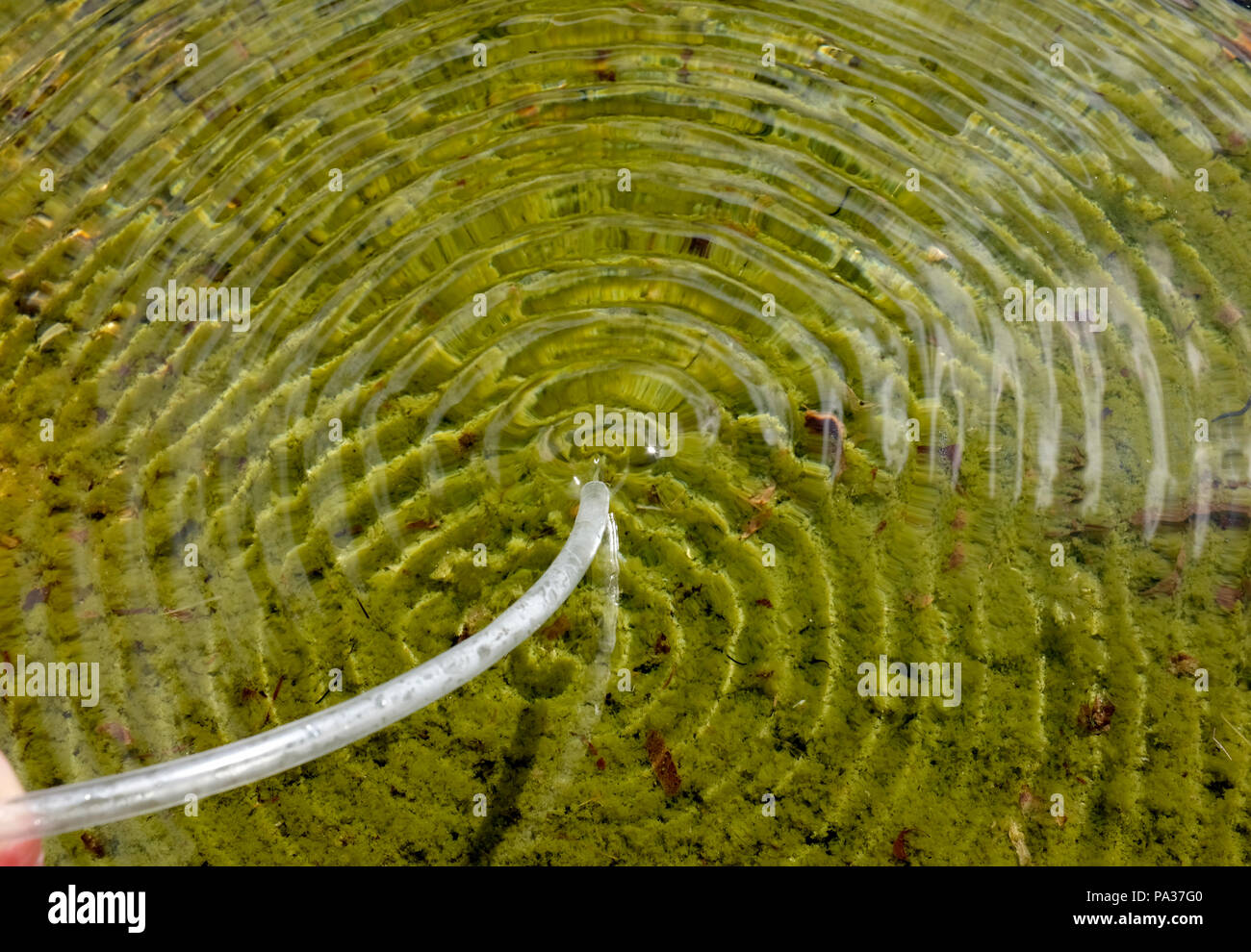 L'origine di waterwaves. L'aria è soffiata sull'acqua, e questo crea un foro nella superficie. Questo foro genera onde d'acqua. Foto Stock