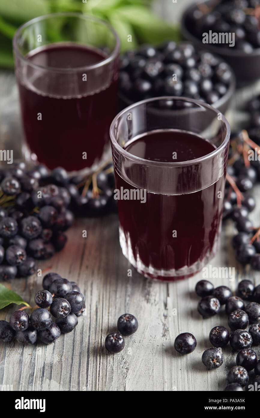 Fresche bacche di Aronia e bacche di Aronia succo in bicchieri Foto Stock