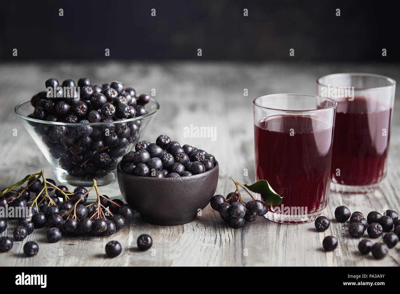 Fresche bacche di Aronia e bacche di Aronia succo in bicchieri Foto Stock