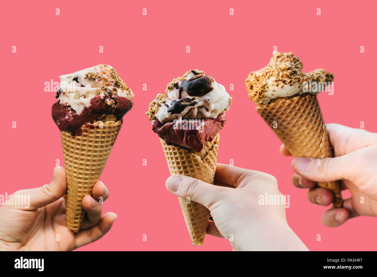 Un gruppo di persone o di amici tenendo il gelato nelle loro mani su un sfondo rosa. Idea creativa di una vacanza o una festa estiva in un concetto stile minimal Foto Stock