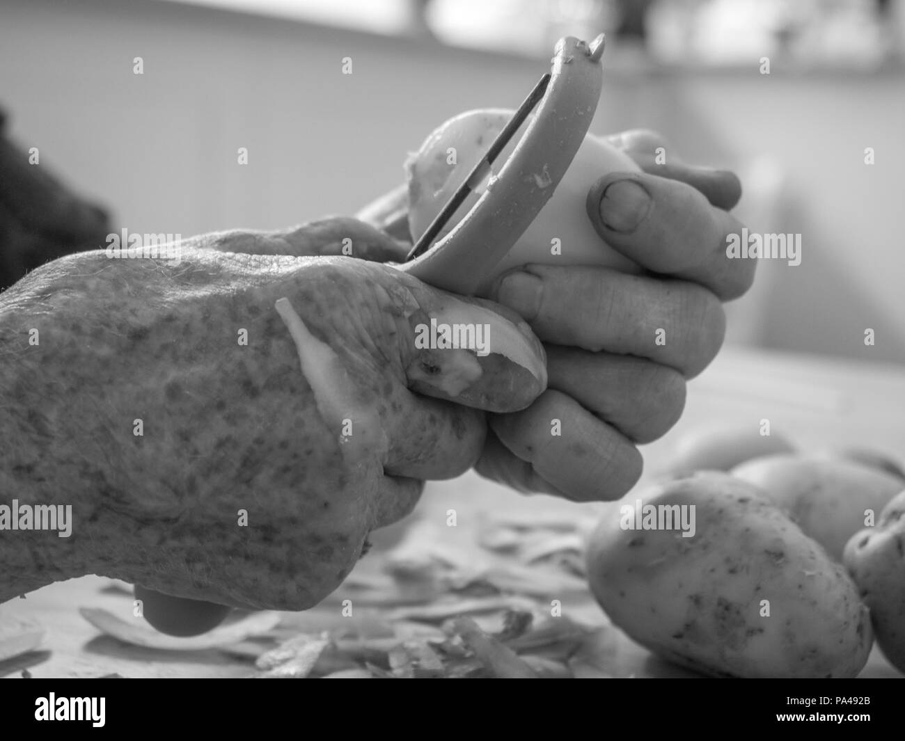 Vecchio, le mani sono la pelatura di patate Foto Stock