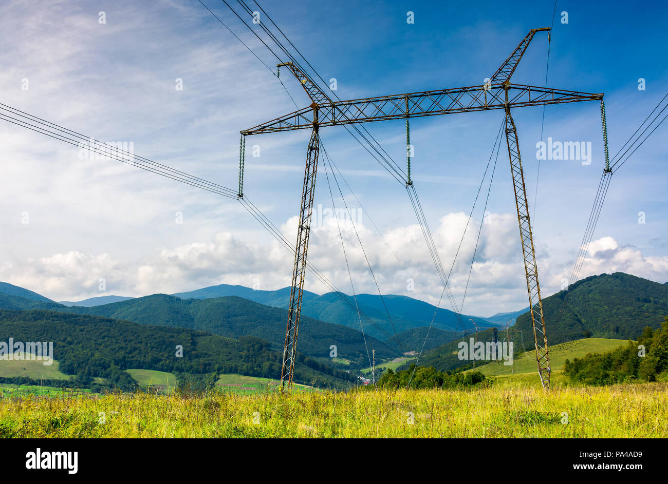 Le linee di alimentazione torre su un prato contro il cielo blu. bella industria energetica sfondo. efficiente di erogazione di elettricità concetto. bello e luminoso cl Foto Stock