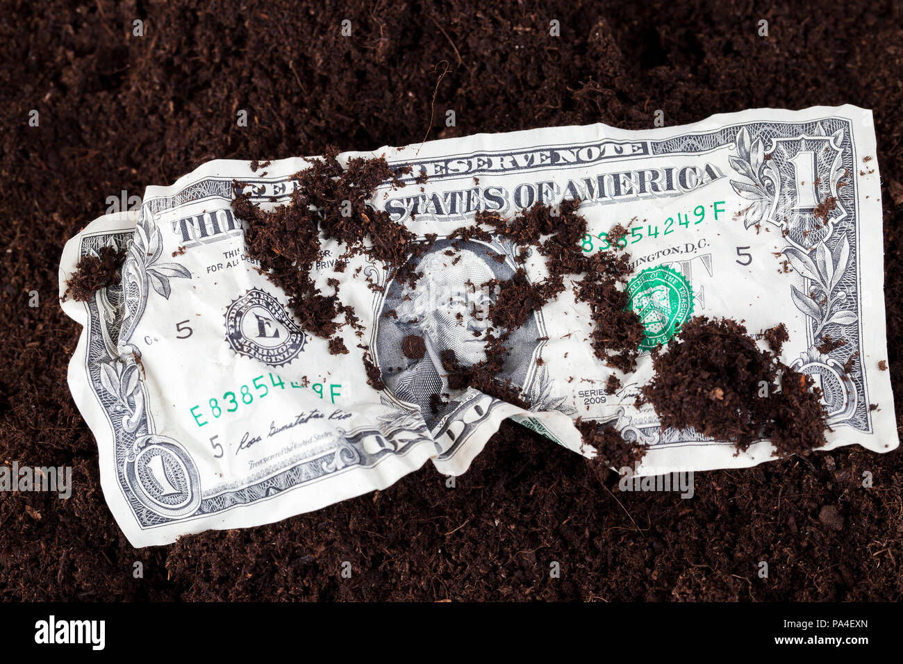 Crumpled un dollaro statunitense giacenti su uno sfondo di colore scuro del suolo, closeup, su una cassa di banconota versata messa a terra Foto Stock