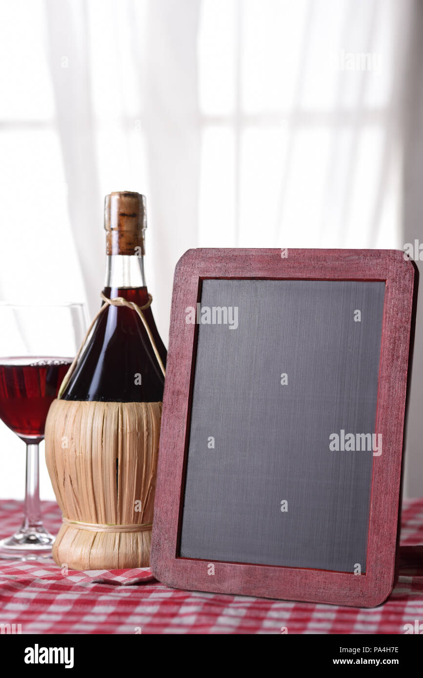 Cestello di una bottiglia di vino Chianti su un rosso a scacchi tovaglia con un vino bianco della scheda del menu. Foto Stock