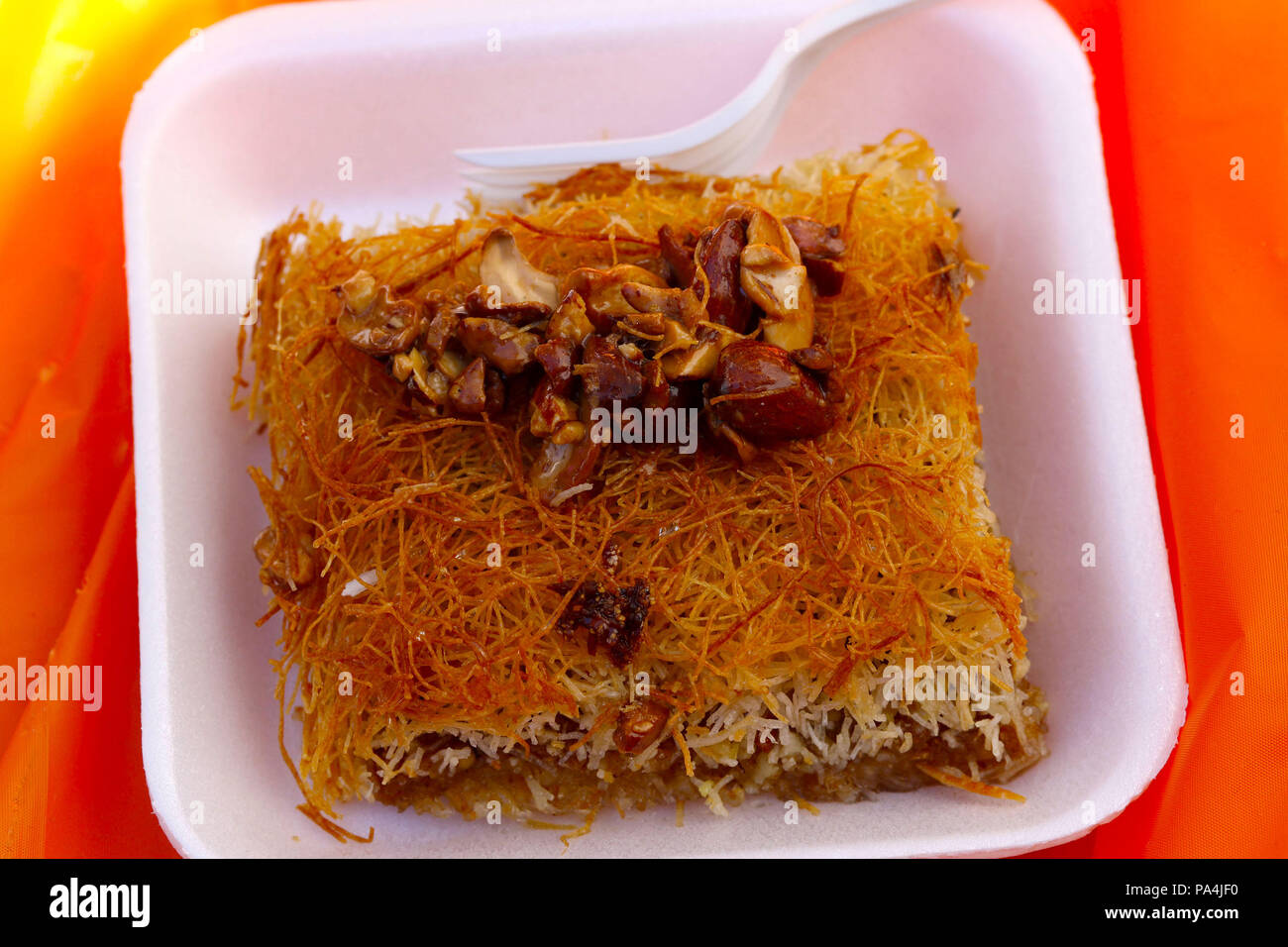 Kanafeh, di un palestinese dolce fatto con noodle-come pasticceria e stratificata con dadi Foto Stock