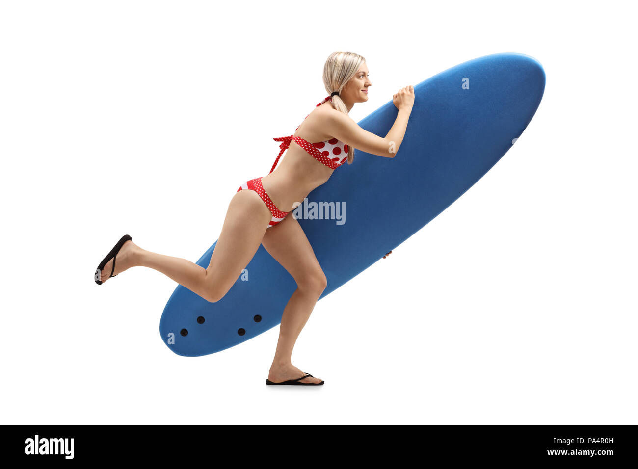 Lunghezza piena ripresa di profilo di una giovane donna con una tavola da surf in esecuzione isolati su sfondo bianco Foto Stock
