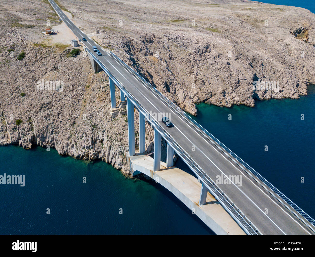 Vista aerea del ponte dell'isola di Pag, Croazia, strade e della costa croata. Scogliera affacciato sul mare. Vetture attraversando il ponte visto da sopra Foto Stock