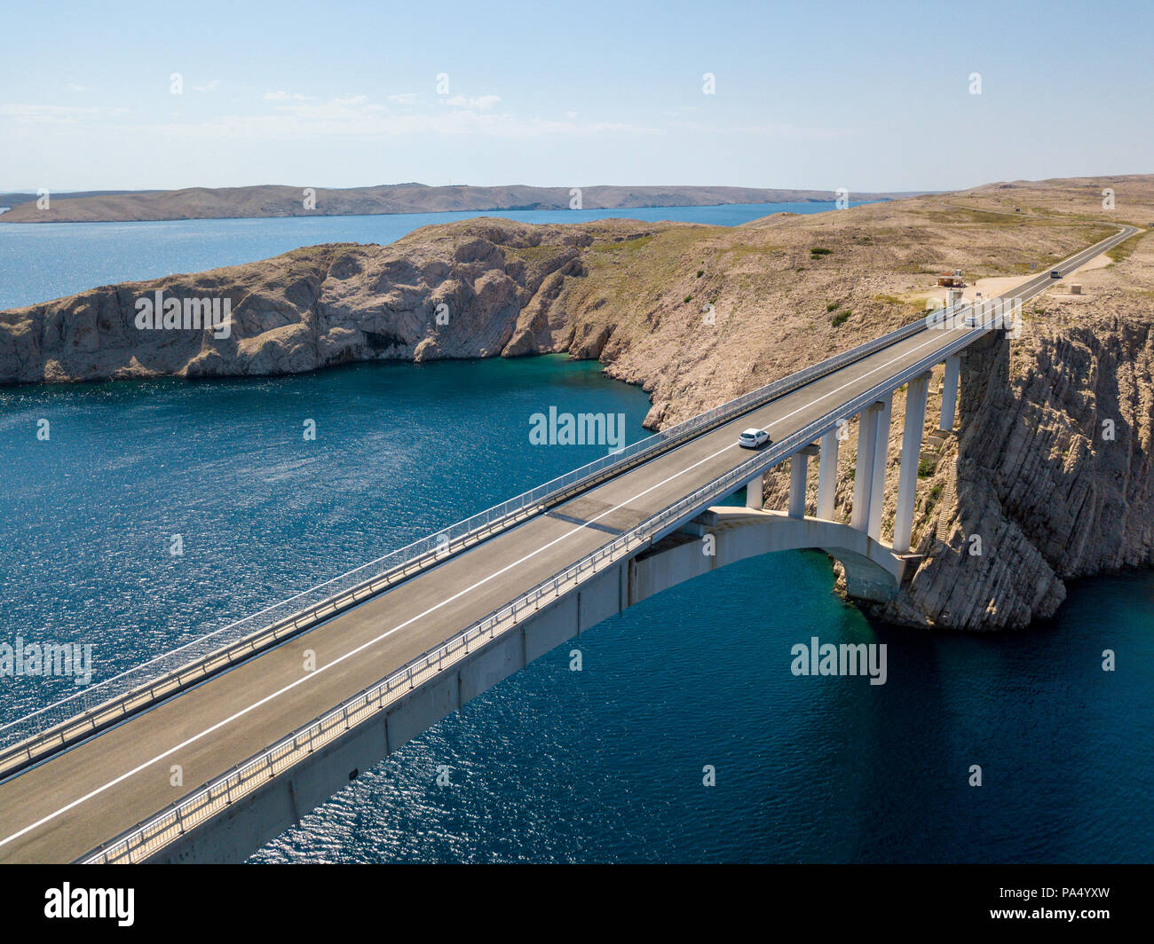 Vista aerea del ponte dell'isola di Pag, Croazia, strade e della costa croata. Scogliera affacciato sul mare. Vetture attraversando il ponte visto da sopra Foto Stock