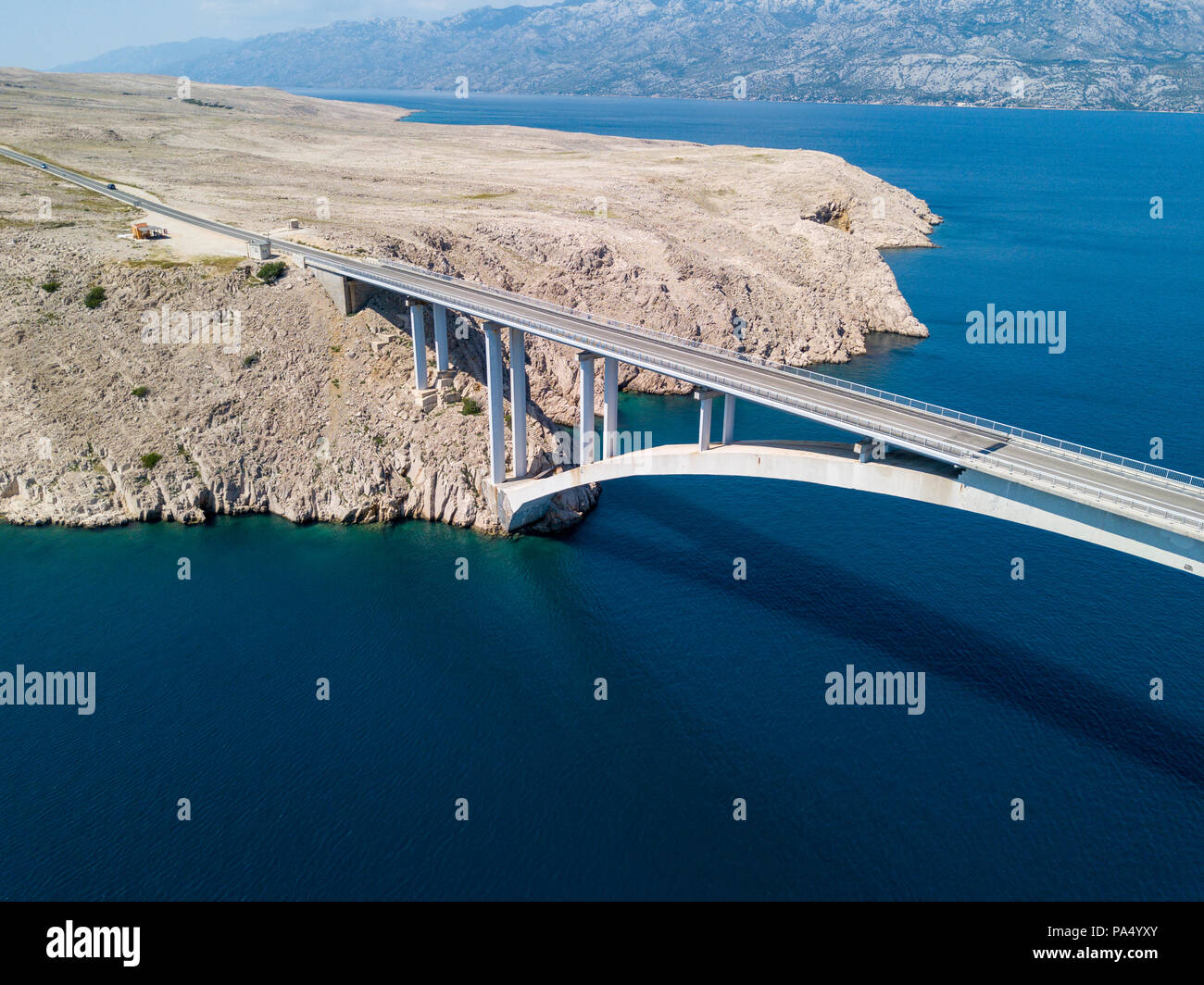 Vista aerea del ponte dell'isola di Pag, Croazia, strade e della costa croata. Scogliera affacciato sul mare. Vetture attraversando il ponte visto da sopra Foto Stock