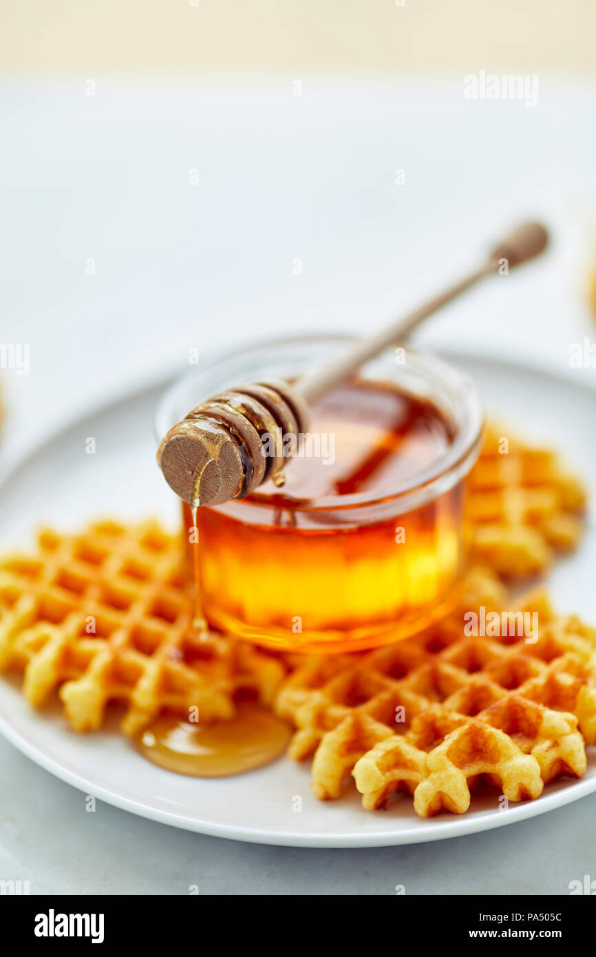 Il miele in un vasetto con la cucchiaia in legno Foto Stock