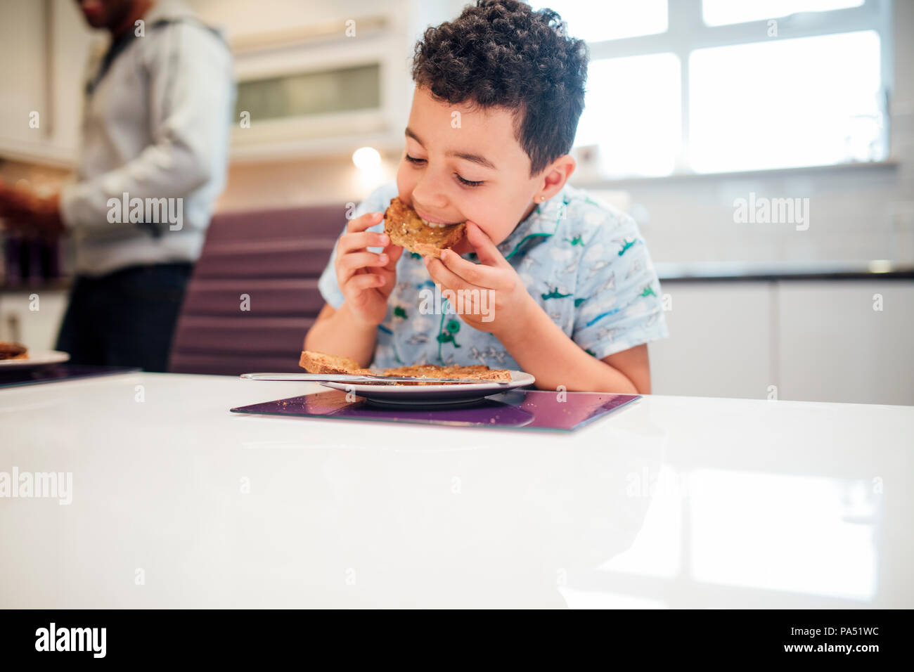 Little Boy sta godendo di qualche toast con marmellata per colazione a casa. Foto Stock
