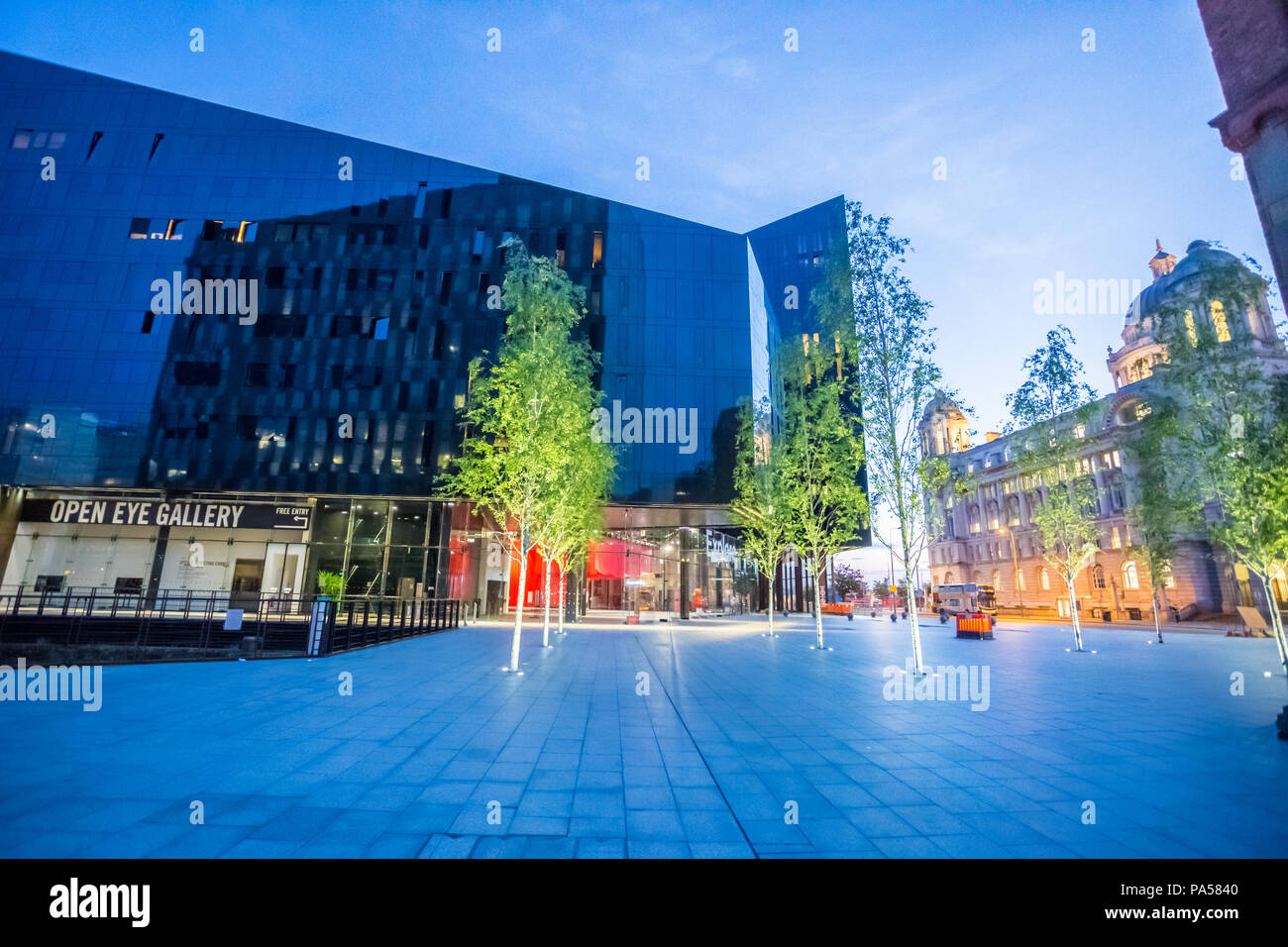 Sera colpo di isola di Mann, Liverpool, con moderno edificio giustapposto contro il vecchio edificio, il porto di Liverpool edificio, con alberi illuminato Foto Stock