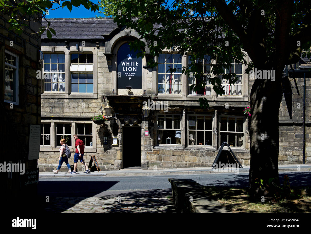 Giovane oltrepassando il White Lion pub di Hebden Bridge, Calderdale, West Yorkshire, Inghilterra, Regno Unito Foto Stock