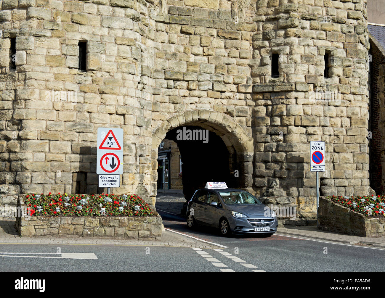 Auto passando attraverso Bondgate Tower, Alnwick, Northumberland, England Regno Unito Foto Stock