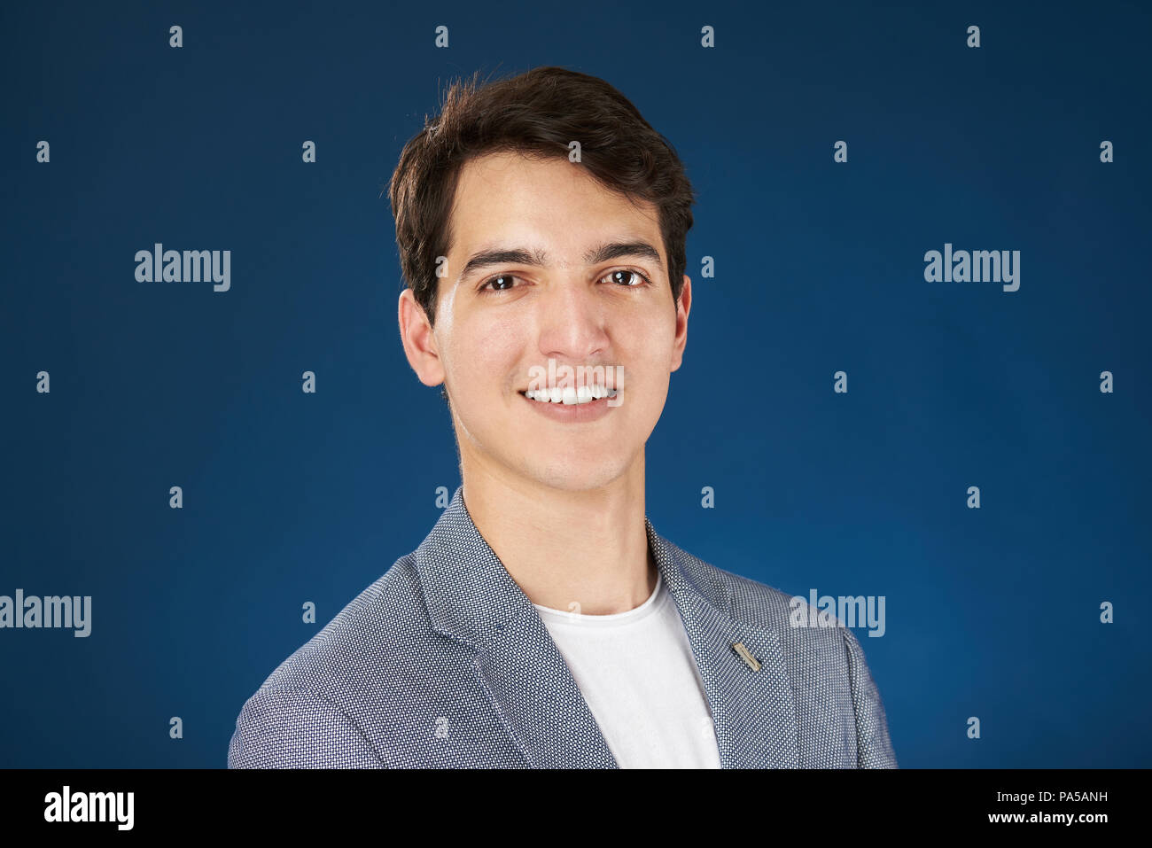 Colpo di Testa di giovani latino-uomo isolato su blu di sfondo per studio Foto Stock