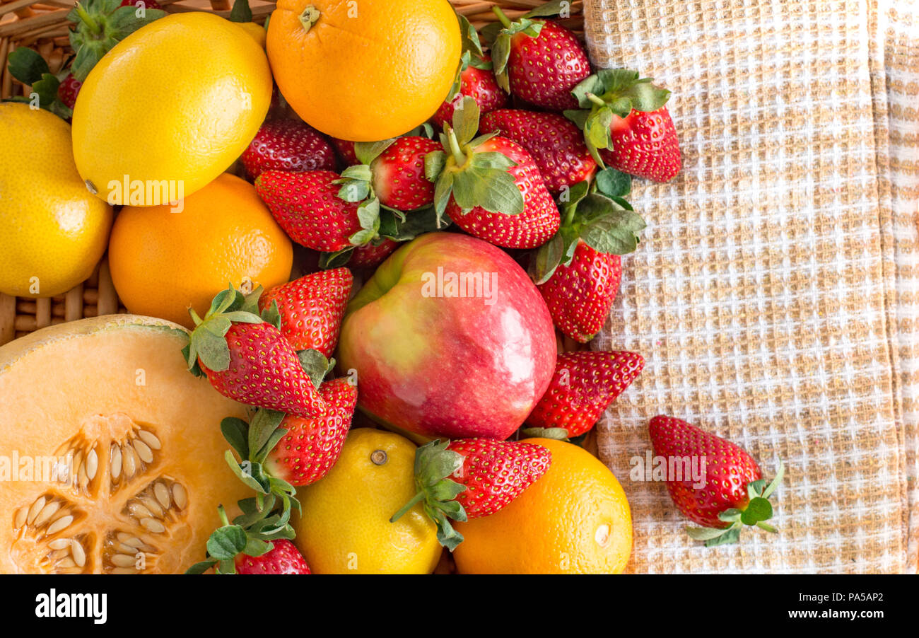 Miscelato un cesto di frutta al limone, arancio, melone e fragole Foto Stock